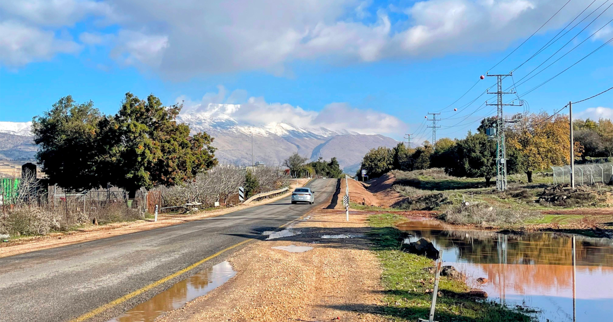 A road that is heading toward high snowy mountains - Golan Heights, Israel